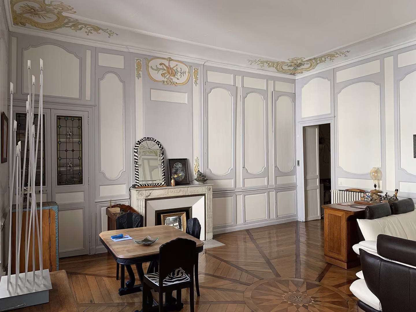 Salon d’appartement ancien avec boiseries, cheminée et parquet marqueté